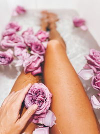 Personal perspective woman in the bathtub full of rose flowers