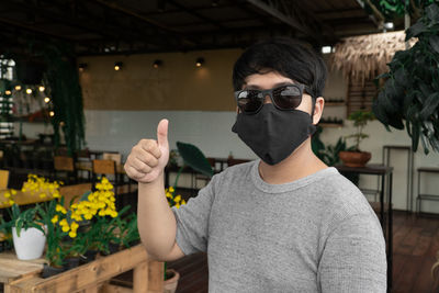 Portrait of young man wearing sunglasses standing outdoors