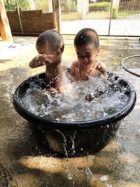 Children playing with water in container