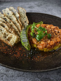 Gourmet fish tartar raw from tuna fillet with hashed avocado, selective focus