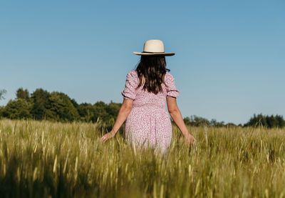 Woman standing on field against clear sky