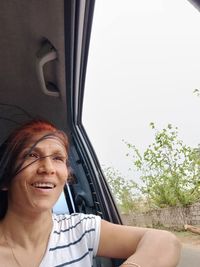 Portrait of a smiling young woman sitting in car