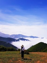 Girl standing on mountain against sky