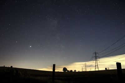 Silhouette electricity pylon against sky at night