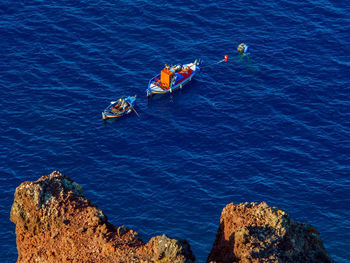 Fisherman catching a fish in the morning, above view from cliff. santorini, cyclades, greece