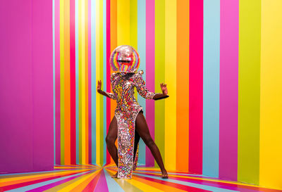 Full length of woman wearing costume against multi colored background