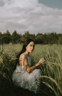 Side view of a young woman lying on field