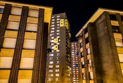 Low angle view of illuminated buildings against sky at night