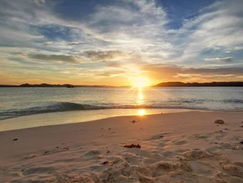 Scenic view of beach against sky during sunset