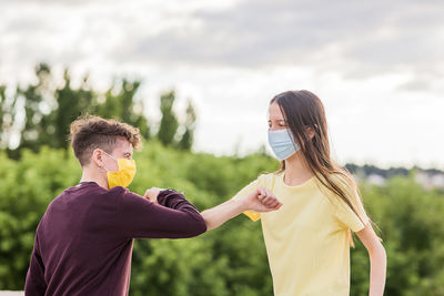 Friends greeting each other during covid-19 pandemic