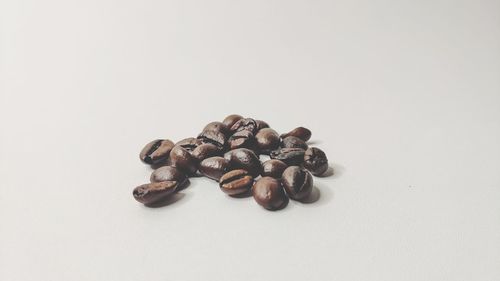 Close-up of coffee beans against white background