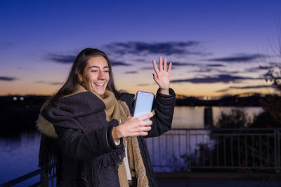Young woman talking on video call during dusk