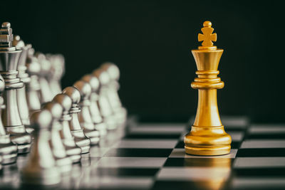 Close-up of chess pieces on board against black background