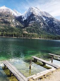 Scenic view of lake by snowcapped mountains against sky