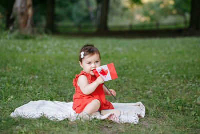 Portrait of cute girl sitting on field