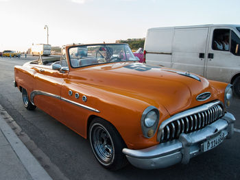 Vintage car on street in city against sky