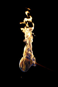 Close-up of lit candle against black background