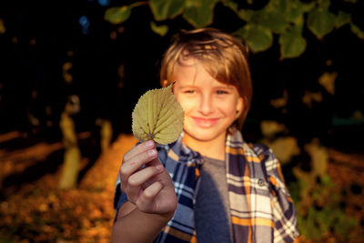 Portrait of young woman holding plant