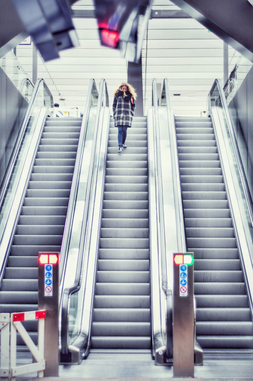 transportation, steps, architecture, men, lifestyles, built structure, indoors, staircase, the way forward, steps and staircases, travel, escalator, full length, low angle view, mode of transport, walking, on the move, railroad station