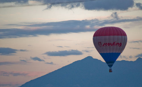 Hot air balloon flying against sky during sunset