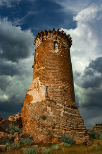 Low angle view of old building against cloudy sky