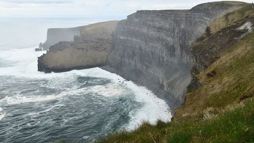 Scenic view of sea by cliff