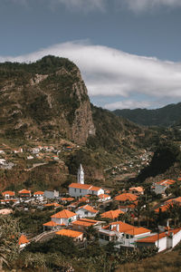 High angle view of townscape by mountain against sky