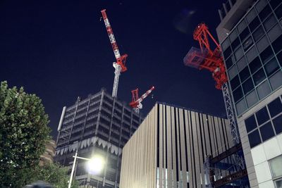 Low angle view of illuminated buildings against sky at night