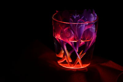 Close-up of red wine glass on table against black background