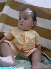 High angle view of cute baby girl on bed at home