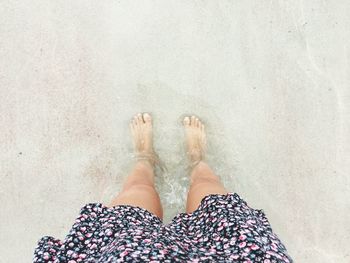 Low section of woman standing on beach