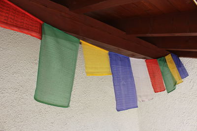 Low angle view of multi colored flags hanging against wall