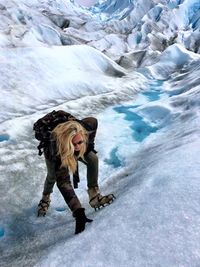 Full length of woman hiking on snowcapped mountains during winter