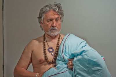 Portrait of mid adult man standing against wall at home