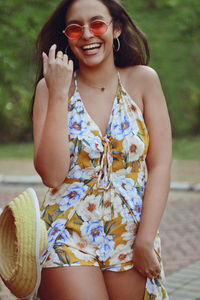 Smiling teenage girl wearing dress standing at park