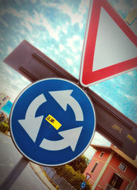 Low angle view of road sign against blue sky