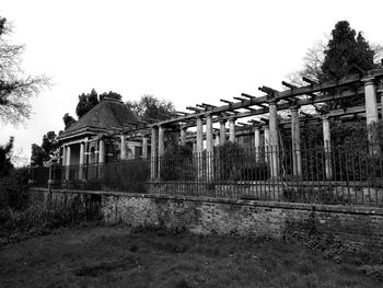 Old building by trees against clear sky