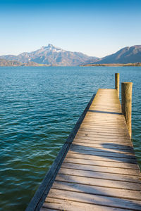 Pier over lake against blue sky