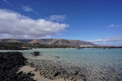 Scenic view of sea and mountains against blue sky. caleton blanco lanzarote. 