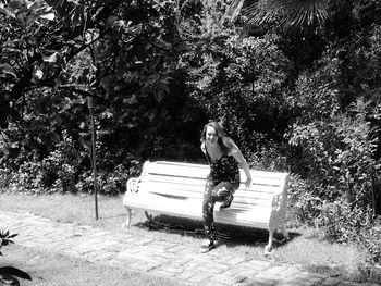 Young woman sitting on tree