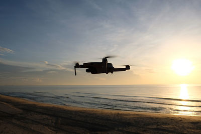Silhouette boat in sea against sky during sunset