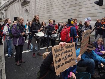 People on street against buildings in city