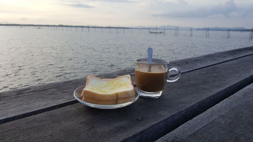 Close-up of breakfast on table against sea