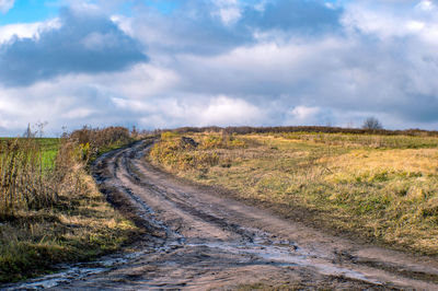 Road amidst field against sky