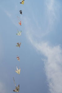 Low angle view of kites flying in sky