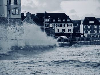 Water flowing in city against sky