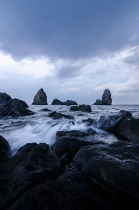 Scenic view of rocks in sea against sky