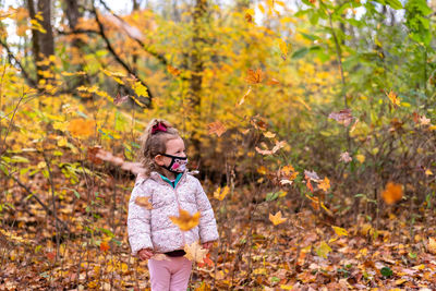 Girl standing on leaves during autumn