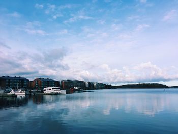 Buildings by sea against sky