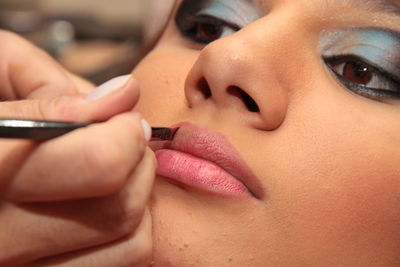 Close-up of beautician applying make-up on woman